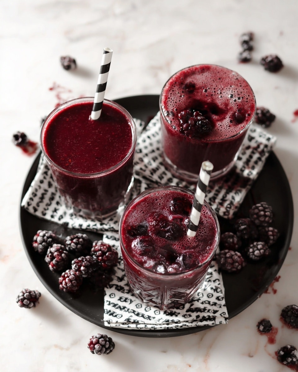 Three clear glasses are filled with a dark purple berry drink, each topped with a light purple foam layer. Each glass holds a black and white striped straw. The glasses sit on a black plate which holds several dark berries around the edges. The whole setup is set on a white marbled surface. Photo taken with an iphone --ar 4:5 --v 7