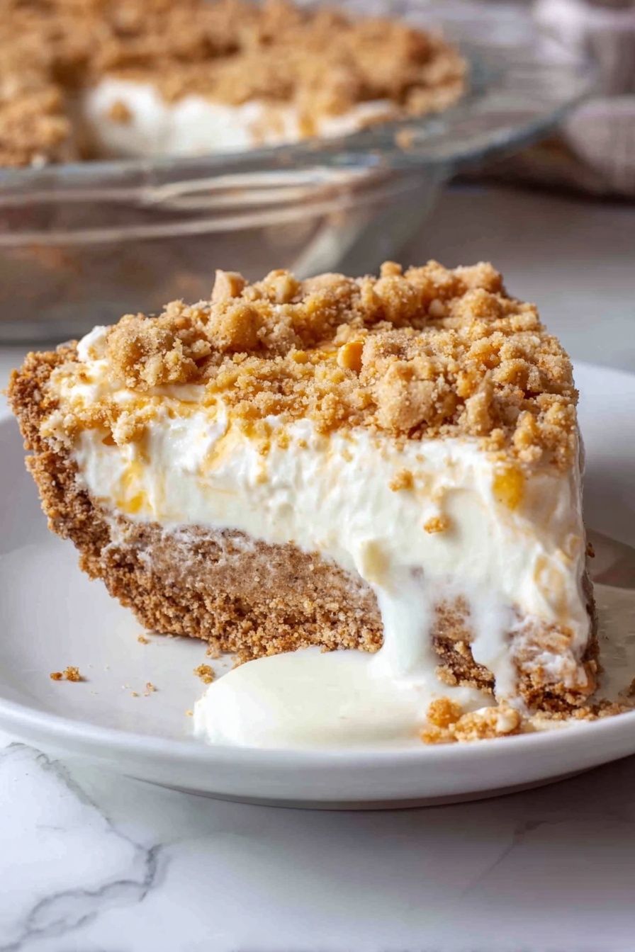 Angel Pecan Pie, pecan pie dessert, fluffy pecan pie, elegant pecan pie, easy holiday pies - A close-up view of a thick, light brown crust with cracks, forming the base layer in a clear glass pie dish, on a white marbled surface. On top of the crust, a fluffy, white cream layer is being spread evenly, poured from a bowl using a blue spatula held by a woman's hand. The cream is soft and smooth, with gentle folds as it lands on the crust, creating a thick second layer. The background shows a blurred maroon fabric. Photo taken with an iphone --ar 2:3 --v 7