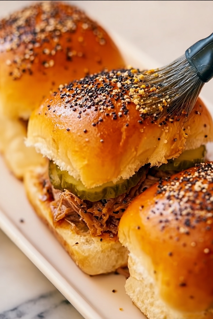Cuban Pulled Pork Sliders, Cuban Pulled Pork Sandwiches, Easy Pulled Pork Sliders, Party Slider Recipes, Flavorful Pulled Pork Snacks - The image shows a close-up of a golden brown bread roll cluster with a shiny surface, sprinkled with white sesame seeds and black poppy seeds. There is a yellow silicone brush with black details gently spreading a glaze on the soft tops of the rolls. The bread rolls appear fluffy and slightly puffy, with visible seams and light texture. The background is a white marbled surface. photo taken with an iphone --ar 2:3 --v 7
