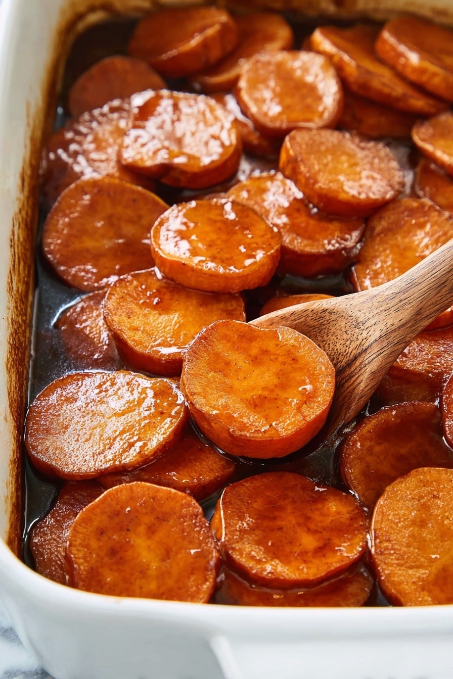 Southern Candied Yams, Southern Candied Yams Recipe, Easy Candied Yam Side Dish, Best Candied Yams, Sweet Yams with Brown Sugar and Cinnamon - The image shows a close-up of a white baking dish filled with thick, round slices of sweet potatoes, cooked in a rich, shiny brown glaze that coats each slice with a sticky texture. The sweet potato slices are arranged in a slightly overlapping layer, showing their smooth and glossy surface with a warm orange-brown color. A wooden spoon is partially visible on the right side, scooping some slices, adding a natural wooden texture to the scene. The background and surface are a white marbled texture. photo taken with an iphone --ar 2:3 --v 7