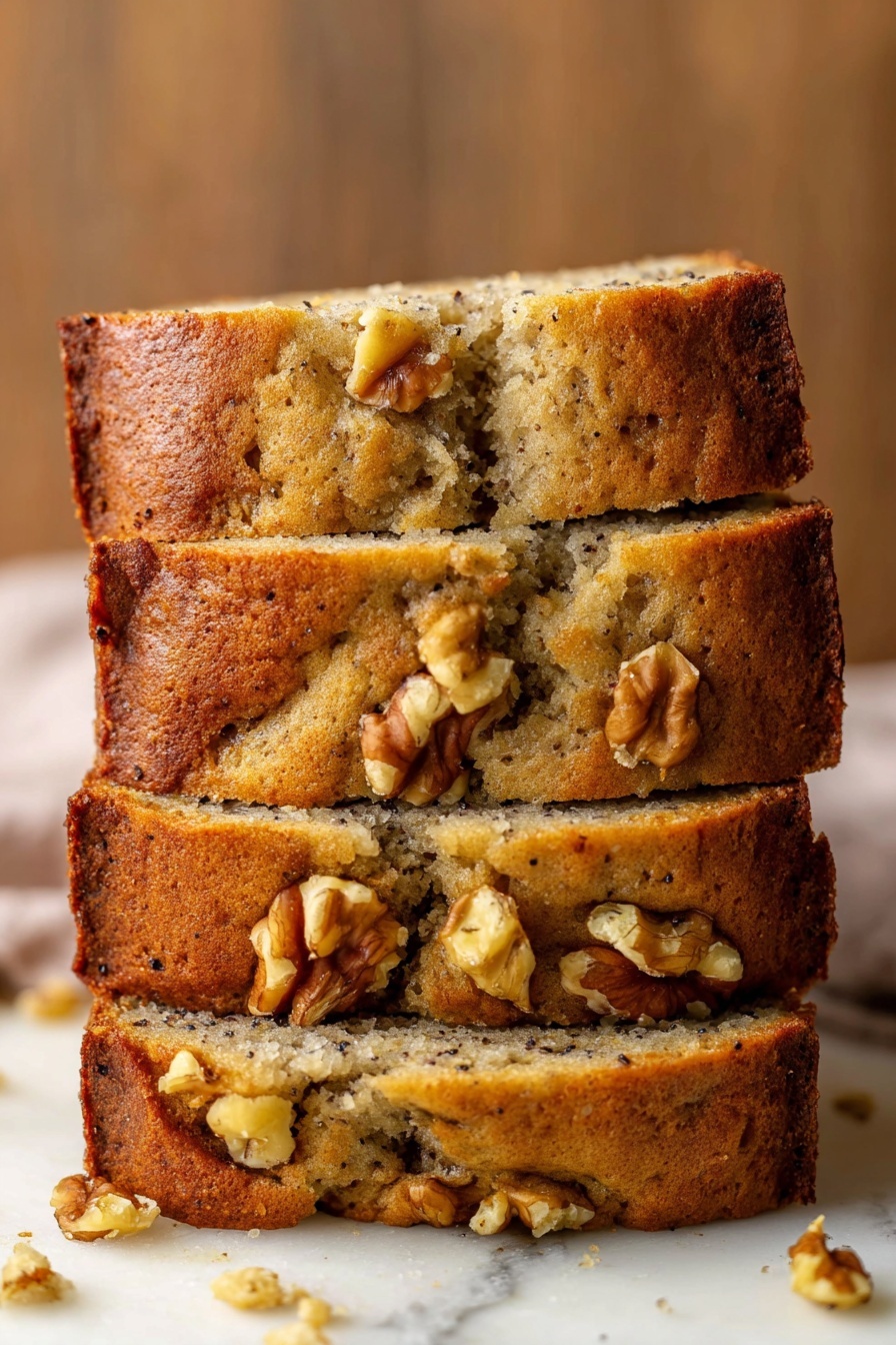 Best Vegan Banana Bread, vegan banana bread recipe, moist vegan banana bread, easy vegan banana bread, healthy vegan banana bread - A stack of four thick banana bread slices sits on a white marbled surface, each slice showing a soft, moist interior with a light brown color and speckles of dark spots from bananas. The crust is golden brown and slightly crumbly with several walnut pieces embedded both on the top and inside the bread. Some walnuts are well visible on the top edges, adding texture. The bread has a homemade rustic look with a few cracks and uneven parts along the sides and top. The background is a warm wooden texture blurred out softly. Photo taken with an iphone --ar 2:3 --v 7