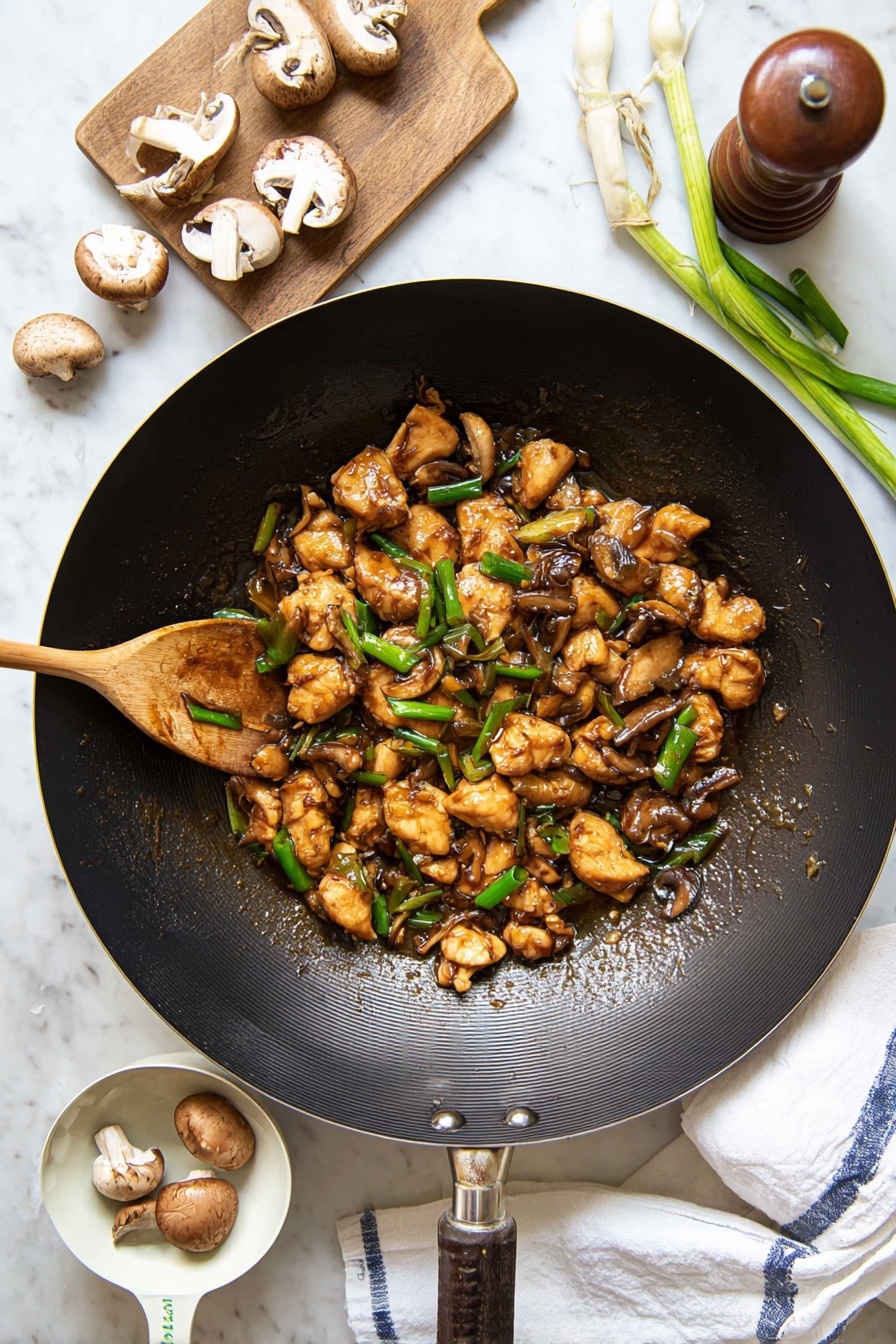 Black Pepper Mushroom Chicken Stir Fry, chicken stir fry recipes, mushroom stir fry, black pepper chicken, easy Asian stir fry - A large black wok filled with several small pieces of golden-brown cooked chicken mixed with sliced brown mushrooms and bright green chopped spring onions, all coated in a glossy brown sauce. A wooden spoon stirs the mixture from the left side of the wok. Around the wok, there are whole and sliced mushrooms, a wooden pepper grinder, fresh green spring onions on a small wooden board, and a white measuring cup holding two mushrooms. The entire scene is set on a white marbled surface with a white cloth towel showing blue stripes placed under the wok’s handle. photo taken with an iphone --ar 2:3 --v 7