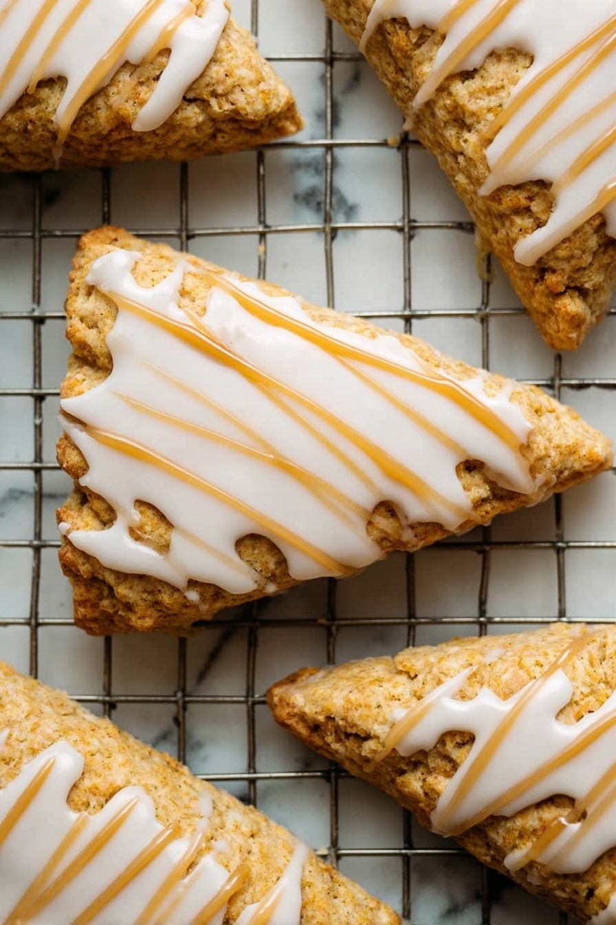 Starbucks Copycat Vegan Pumpkin Scones, vegan pumpkin scones recipe, vegan fall bakery ideas, homemade pumpkin scones, dairy-free pumpkin scones - A close-up of a single orange-brown bar with a soft, crumbly texture showing a bite taken on one side, topped with a thick layer of smooth, creamy white icing drizzled in parallel lines across the top. The bar is held delicately by a woman's hand with a blurred white marbled background. The focus is on the detailed texture of the bar and the glossy icing with a warm, soft lighting. Photo taken with an iphone --ar 2:3 --v 7
