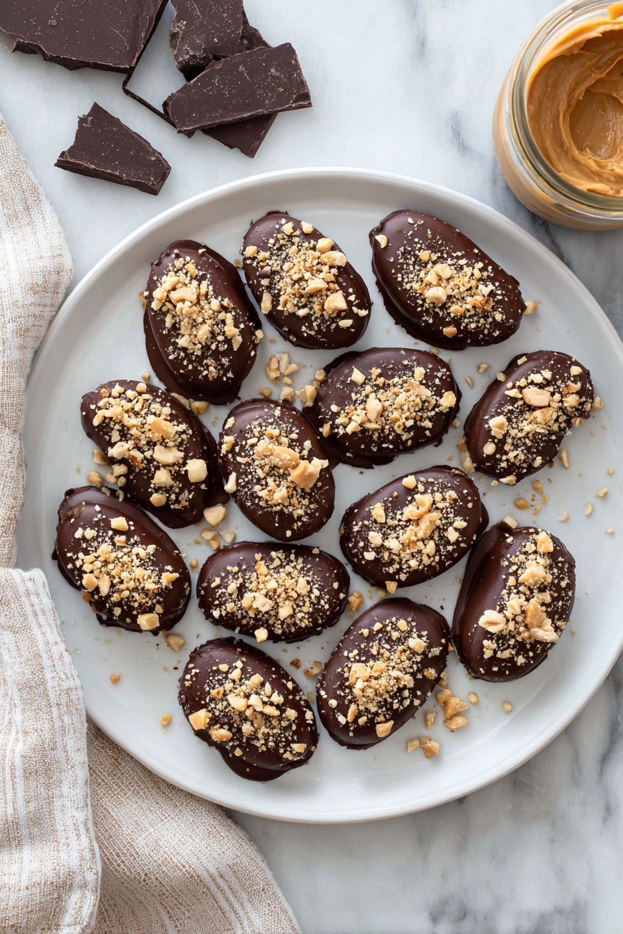 Chocolate-Dipped Peanut Butter Stuffed Dates, peanut butter stuffed dates, chocolate date snacks, healthy date treats, easy dessert bites - A white plate holds a dozen small oval treats, each fully covered in smooth dark chocolate with a shiny finish. On top of every treat, there is a sprinkling of light brown crushed nuts, adding a rough texture. The plate rests on a white marbled surface, with pieces of dark chocolate on the left and a jar filled with creamy light brown peanut butter on the right side. A beige and white striped cloth is placed next to the plate on the left. photo taken with an iphone --ar 2:3 --v 7