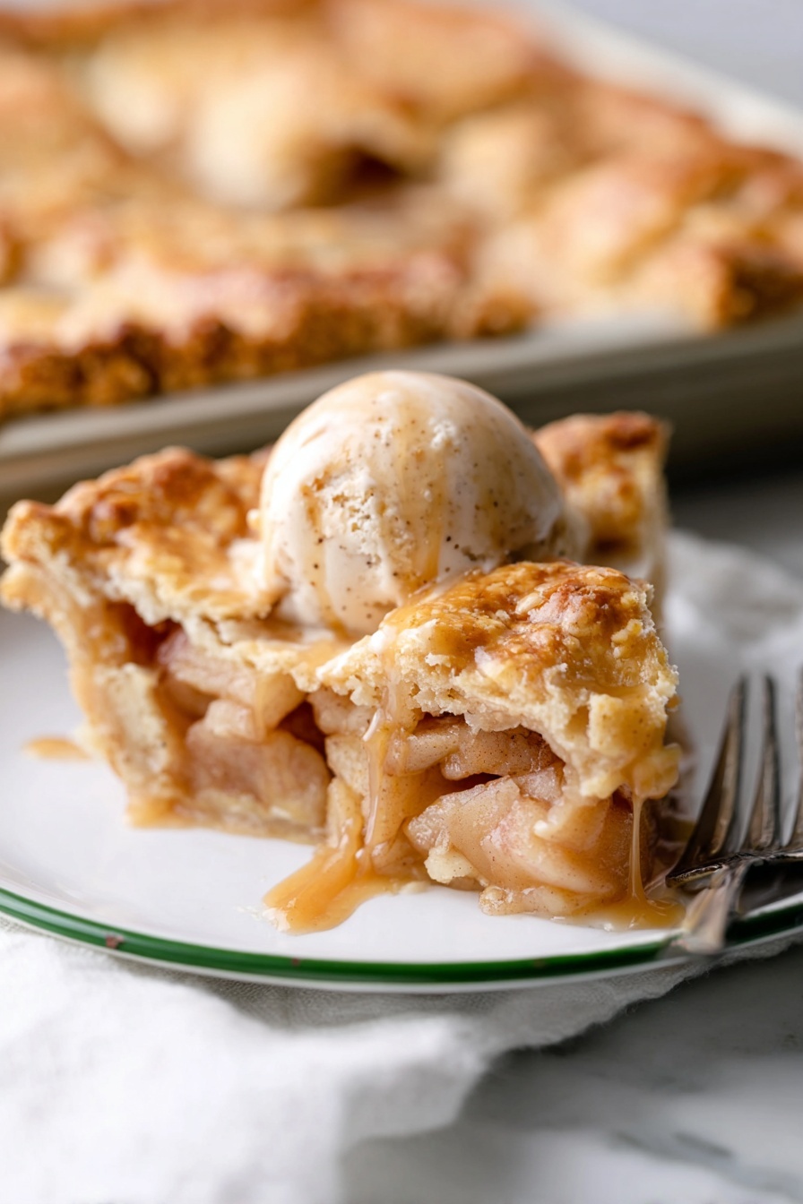 Easy Apple Slab Pie, apple slab pie, rustic apple pie, homemade apple pie, easy dessert recipes - A white plate with a green rim holds a slice of apple pie topped with a scoop of cinnamon ice cream. The pie slice has several golden, flaky layers of crust on top and bottom, filled with soft, light brown cooked apple pieces surrounded by a glossy syrup. On the ice cream, dark brown caramel sauce slowly drips down the sides. In the background, part of the remaining pie sits on a baking tray on a white marbled surface, with a silver fork nearby. photo taken with an iphone --ar 2:3 --v 7