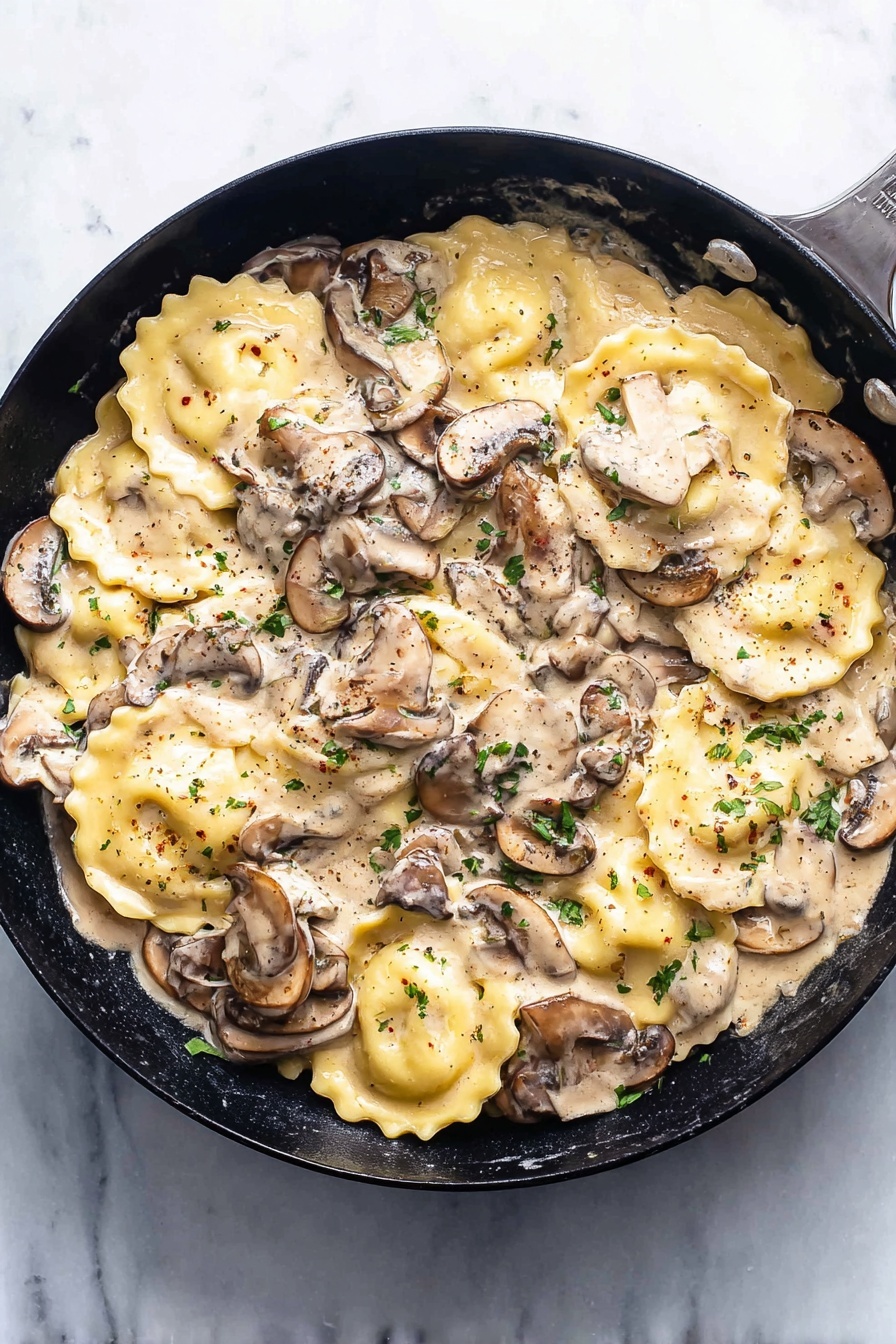 Creamy Mushroom Ravioli, mushroom ravioli recipe, easy mushroom pasta, quick creamy mushroom sauce, indulgent mushroom pasta meal - The image shows a black pan filled with a creamy mushroom sauce and round ravioli pasta. The ravioli are light yellow with slightly ruffled edges, spread throughout the pan. Layered on and around the pasta are sliced mushrooms in different shades of brown and beige, mixed with small green parsley bits for garnish. The creamy sauce is thick, light beige, and covers the ravioli and mushrooms evenly, with visible black pepper flecks on top. The pan is placed on a white marbled surface, and the overall scene is bright and clean. photo taken with an iphone --ar 2:3 --v 7