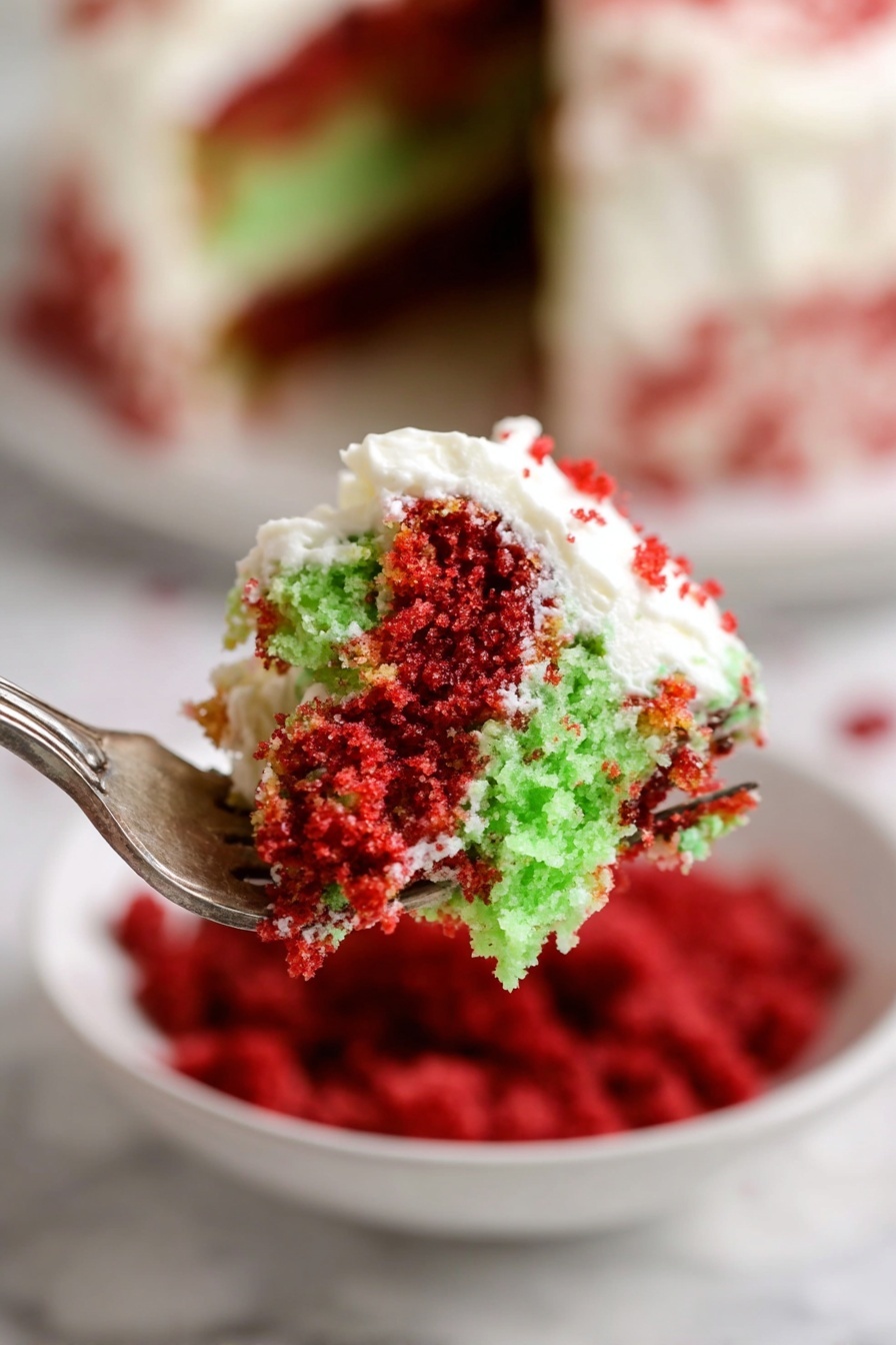 Christmas Red Velvet Trifle, festive red velvet dessert, holiday trifle recipe, Christmas layered cake, easy Christmas dessert - A close-up view of a fork holding a bite of two-layer cake with bright red and light green crumb layers, topped with white creamy frosting that is slightly spread over both layers, showing a mix of crumb textures and smooth frosting. In the background, a white bowl filled with red crumbs and a white marbled surface are slightly blurred, enhancing focus on the cake piece. The layering and vivid colors make the dessert look inviting and fresh. photo taken with an iphone --ar 2:3 --v 7