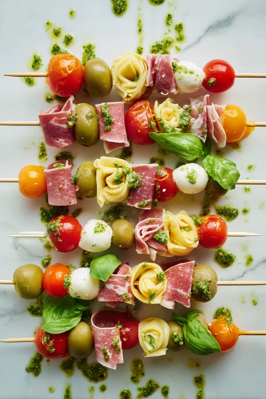 Antipasto Skewers with Tortellini and Cheese, Italian appetizer recipes, easy party appetizers, cheese and charcuterie skewers, make-ahead appetizer ideas - The image shows several skewers with five to seven layers each, arranged side by side on a white marbled surface. Each skewer has colorful ingredients stacked in this order from top to bottom: red cherry tomatoes or orange cherry tomatoes, green basil leaves or whole green olives, light yellow tortellini pasta, thin swirled slices of pink cured meat, and white cheese cubes or white mozzarella balls. Some layers also have small pieces of bright red roasted pepper. Green pesto sauce is drizzled over the skewers and on the surface around them, adding an extra texture and shine to the image. The overall look is fresh, vibrant, and neatly arranged. photo taken with an iphone --ar 2:3 --v 7