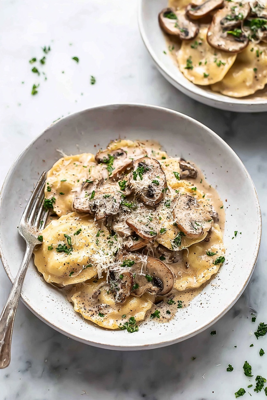 Creamy Mushroom Ravioli, mushroom ravioli recipe, easy mushroom pasta, quick creamy mushroom sauce, indulgent mushroom pasta meal - The image shows a white bowl filled with two layers of round ravioli pasta covered in a creamy light brown mushroom sauce with visible slices of brown mushrooms on top and scattered parsley leaves for garnish. The sauce coats the pasta fully, giving a smooth, glossy texture, and there is a sprinkle of black pepper and grated cheese on top. A silver fork is placed on the left edge of the bowl resting against the side. In the background, there is a second bowl, similarly filled, placed on a white marbled surface with small bits of parsley scattered around. photo taken with an iphone --ar 2:3 --v 7