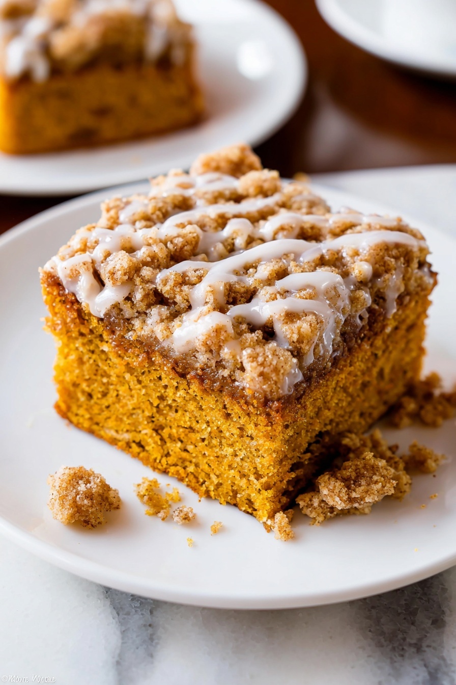 Pumpkin Crumb Coffee Cake, Pumpkin Crumb Coffee Cake recipe, Pumpkin spice coffee cake, Fall coffee cake with crumb topping, Pumpkin dessert with glaze - A close-up of a baked dessert square with two layers on a white plate with a raised dotted edge. The bottom layer is soft and moist, golden brown with a crumbly texture. The top layer is a thicker, crumbly streusel with a light brown color and a drizzle of white icing. A piece has been taken out with a silver fork resting on the plate holding some crumbs and icing. The plate sits on a white marbled surface. Photo taken with an iphone --ar 2:3 --v 7