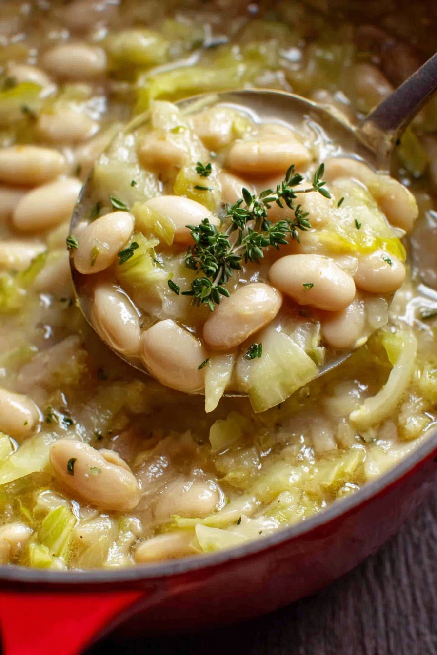 Creamy Butter Bean and Leek Skillet, creamy leek and bean dish, easy vegetarian skillet recipe, comforting leek and beans meal, quick plant-based dinner - The image shows a close-up view of a red pot filled with a warm soup made of white beans and chopped green cabbage pieces in a light broth. The beans are smooth and oval-shaped, scattered evenly throughout the soup, while the cabbage is soft and lightly translucent with a pale green color. Small specks of black pepper and fresh thyme sprigs are sprinkled on top for garnish. The pot has a shiny red exterior with a white interior and two handles on the sides. The pot is sitting on a white marbled surface. Photo taken with an iphone --ar 2:3 --v 7